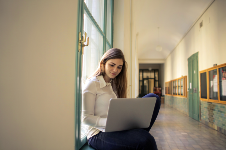 nuotrauka, kurioje studentė ant palangės su kompiuteriu / photo of a student on a windowsill with a computer