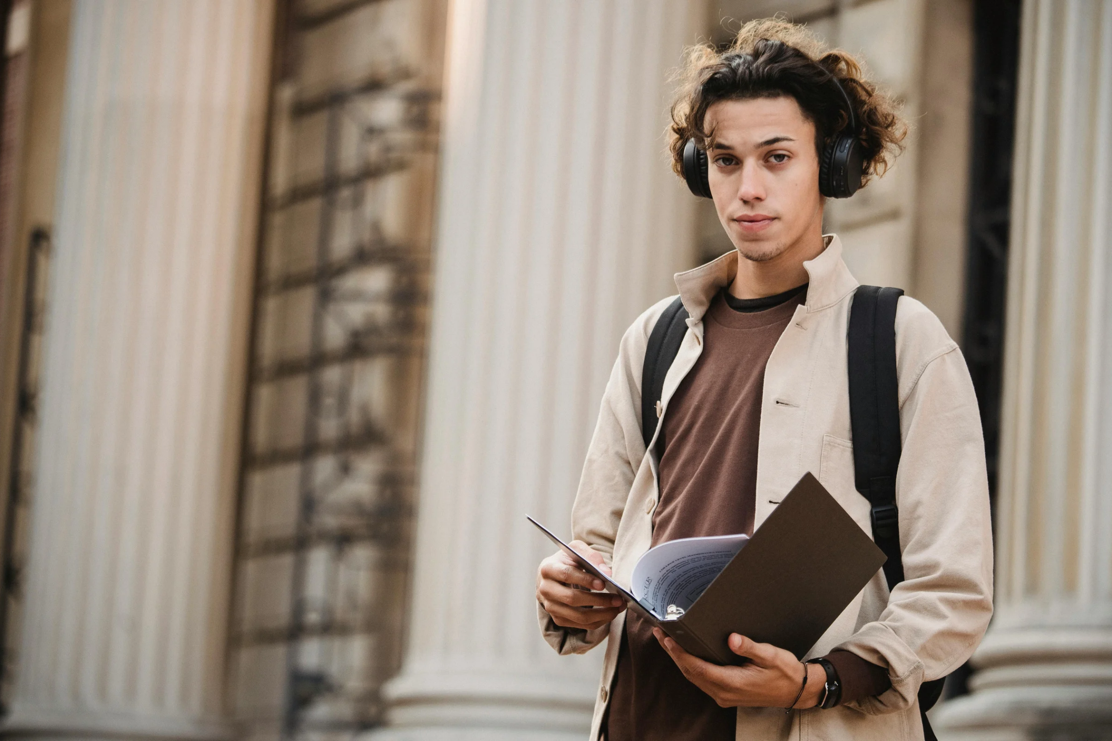 studentas su segtuvu / male student with a binder