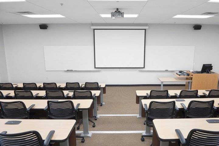 Lietuviškai: Mokymo erdvė, paruošta prezentacijai, su lenta ir projektoriumi. English: A teaching space set up for a presentation, featuring whiteboards and a projector.
